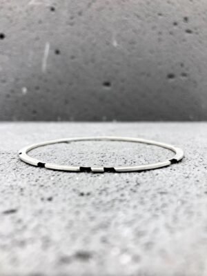Second image of product: Asymmetrical sterling silver bangle with oxidized details in minimalist design